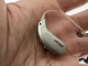 chroma beige oticon real hearing aid in half of hand