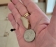 Genesis AI in the palm of hand next to a quarter to show scale