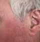 Genesis AI in the left ear with only the receiver wire barely visible to others