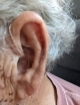 Close up of a single left moment sheer 440 device on the users left ear