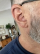 close up of real 1 hearing aid sitting in the right ear