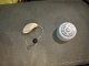 beige genesis ric RT 24 hearing aid next to a bottle cap to show size