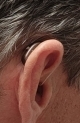 close up of dark cherry sheer 440 hearing aid on right ear