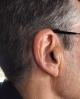 Signia Silk with black faceplate sitting discreetly in users right ear