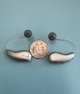 Silver Grey Phonak Audeo Sphere Infinio 90 hearing aids with a quarter- different angle