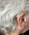 A single right audeo sphere 90 hearing aid in silver grey behind users ear