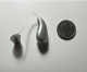 Phonak Audeo Sphere 90 next to a quarter to show size