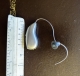 single phonak sphere hearing aid next to ruler