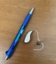 single right audeo sphere 90 hearing aid in sand beige next to pen for scale