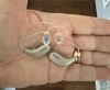 2 oticon intent 1 hearing aids in color chroma beige in hand