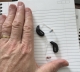 oticon intent 1 pair in diamond black on a table next to hand for scale