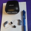 Oticon Intent 1 in sky blue next to charger and pen for scale