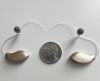 Pair of Starkey Edge AI 24 mRIC 24 hearing aids on table with coin
