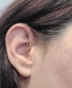 Oticon Zircon 1 right hearing aid in color black on right ear up close