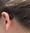 left Phonak Audeo Sphere 90 in chestnut brown behind the ear with hair pulled back