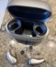 Pair of Audeo Sphere 90 in champagne next to charger on counter