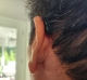 Starkey Edge AI RIC RT 24 in color tech black on left ear close up from behind
