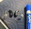 Pair of oticon intent 1 r hearing aids in diamond black next to marker for scale