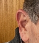 Starkey Edge AI 24 in graphite grey on right ear closeup