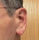 Starkey Edge AI 24 in graphite grey on left ear closeup