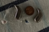 oticon intent 2 in terracotta on table next to coin for scale