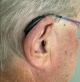 Right Phonak Sphere 90 in chestnut on ear
