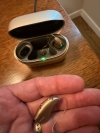 Phonak Audeo Infinio Ultra Sphere 90 in sand beige in hand with charger in background