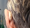 starkey omega ai 24 in beige in left ear from behind