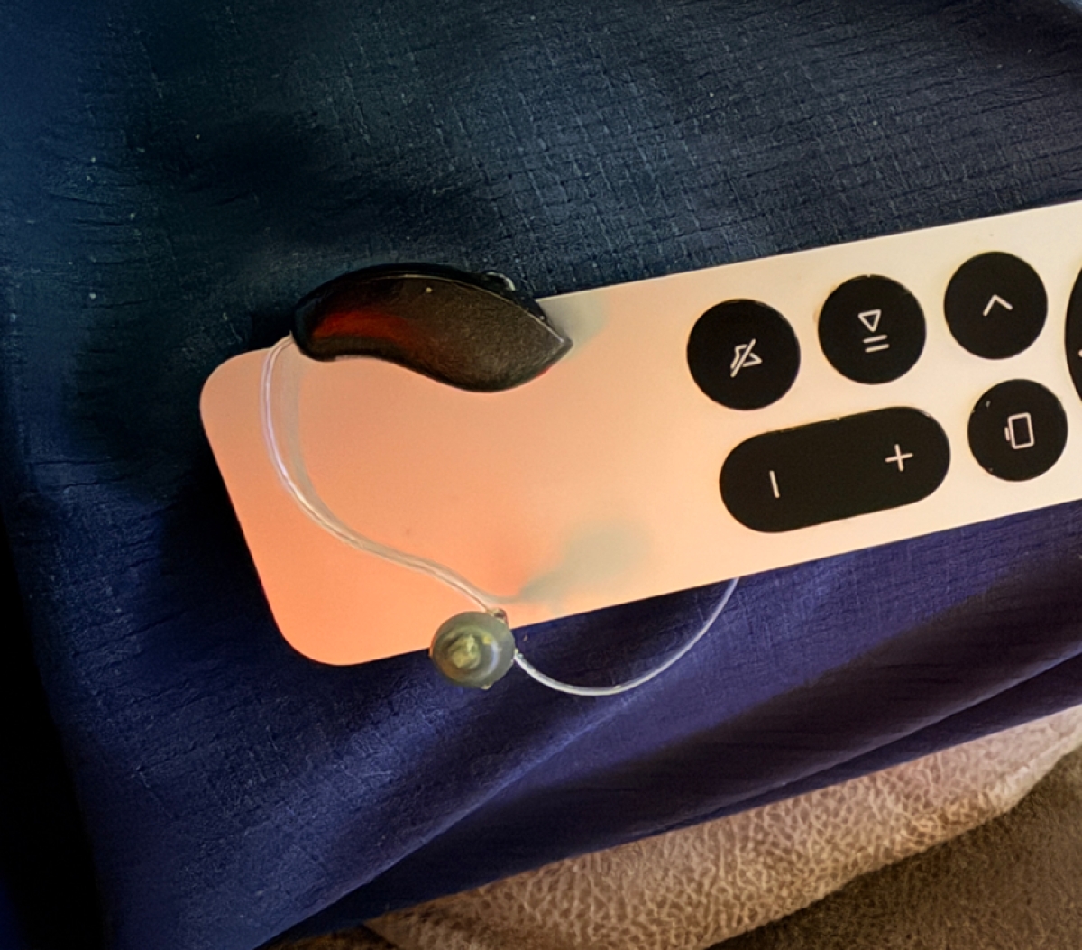 Starkey Omega AI 24 in black on tv remote control for scale