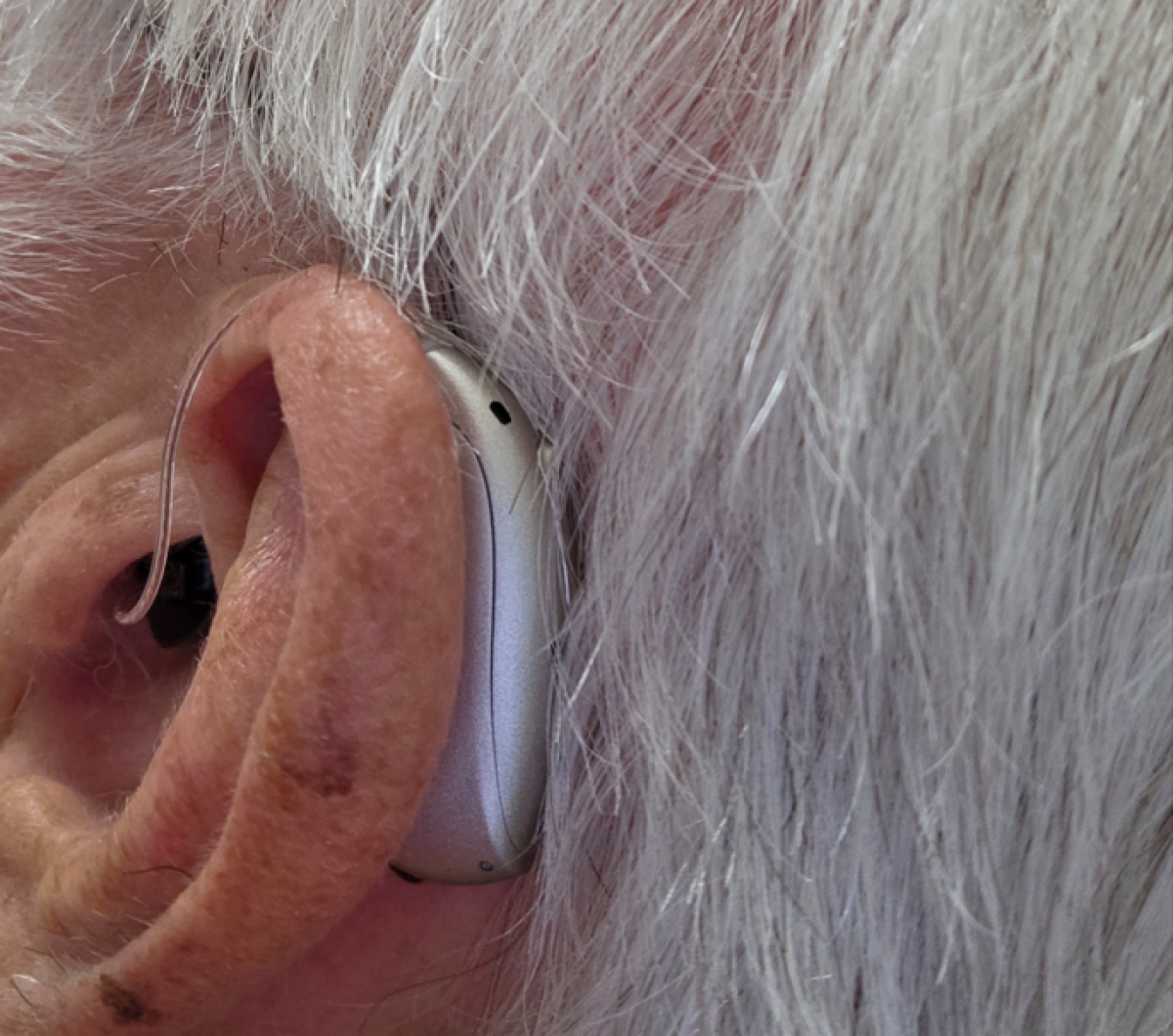 Audeo Sphere 90 in champagne behind left ear close up