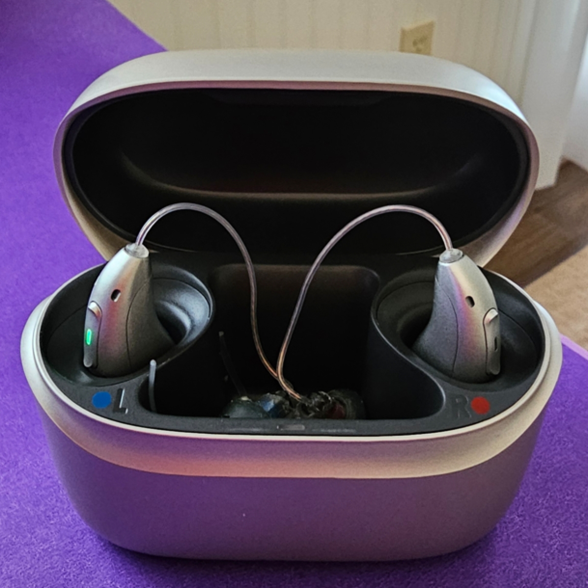 pair of Phonak infinio ultra sphere 90 in silvery grey in charger