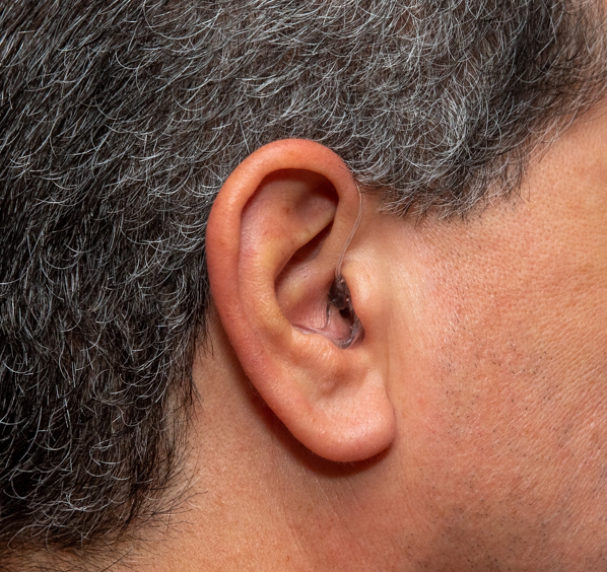 Starkey Omega AI 24 in graphite grey on right ear from right profile