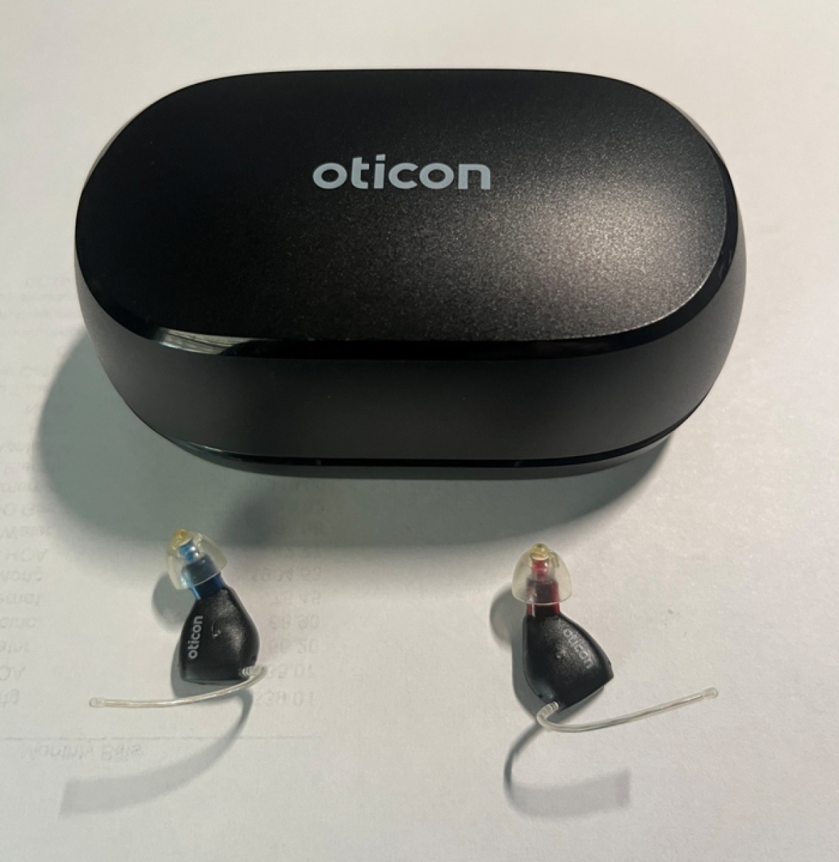 pair of oticon zeal on table next to charger