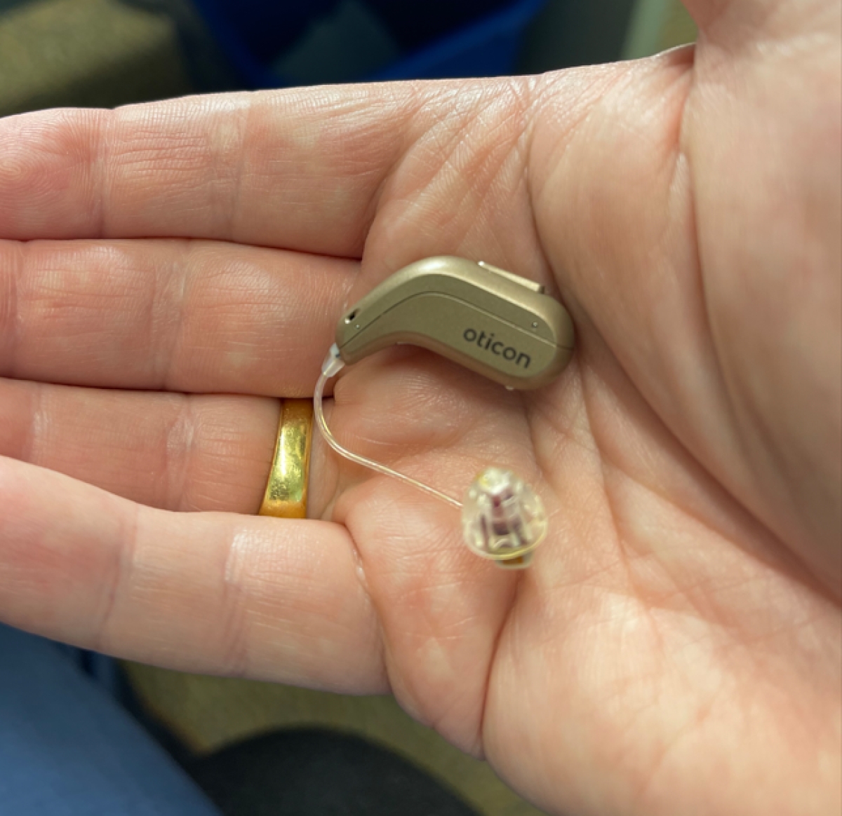 oticon reveal 1 minirite R in honey beige in palm of hand