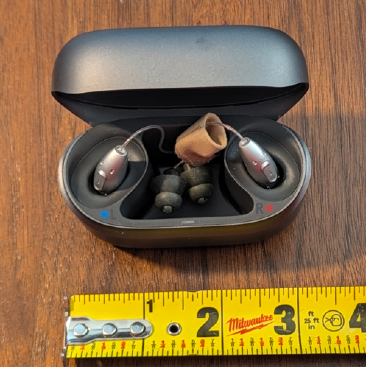 Phonak Audeo EON Sphere 90 in color silver grey in charger on table next to ruler