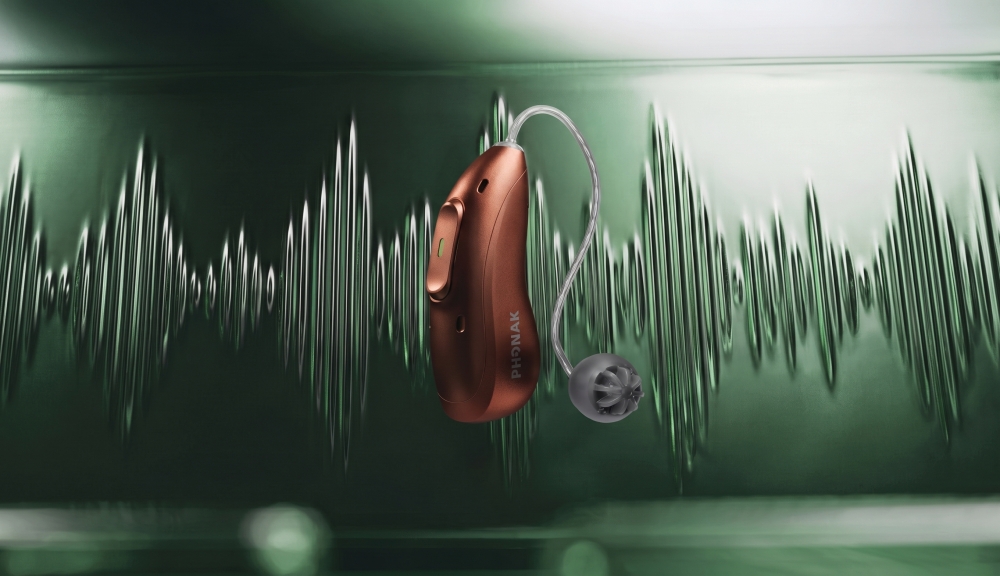 Phonak Audéo EON Sphere hearing aid in Sienna Red against a dark green background with stylized sound waves.