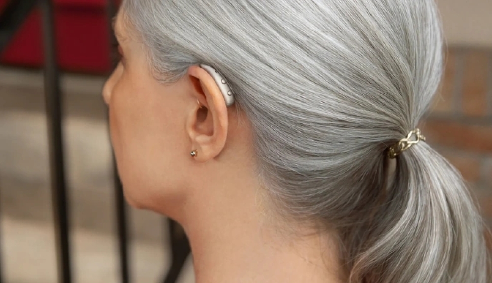 photo of the new signia max on a womans left ear in color dark chamapgne